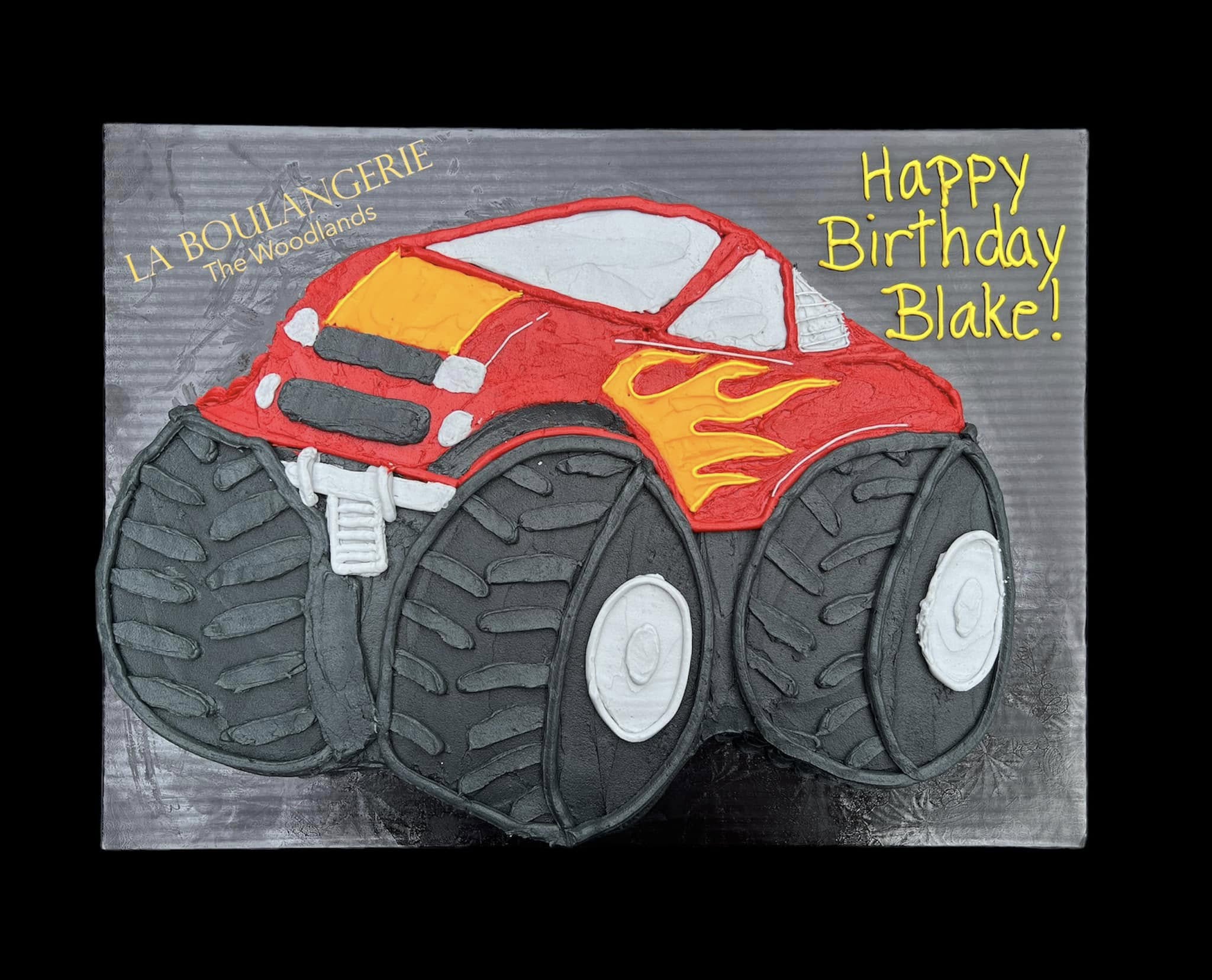 Custom monster truck shaped birthday cake with detailed icing, decorated by La Boulangerie