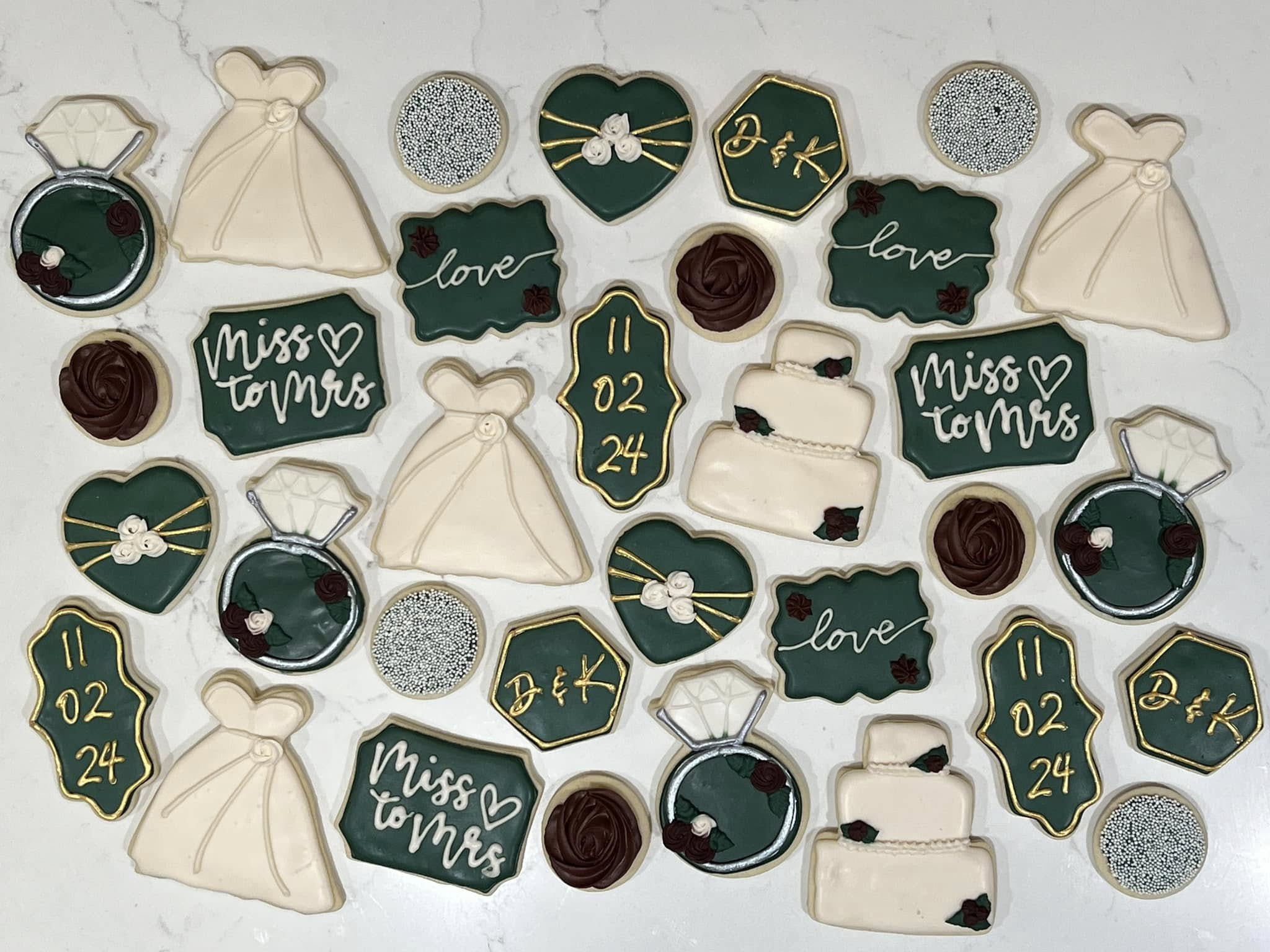 Beautifully decorated wedding cookies with dark green, gold, and ivory icing featuring rings, dresses, and wedding dates